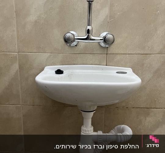 כיור עם ברז וצנרת מתחת